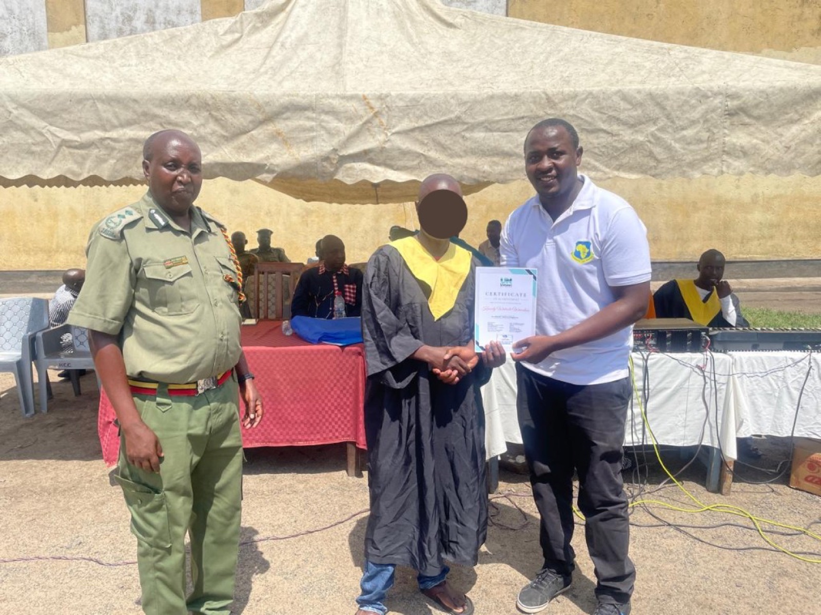 Graduate receiving a certificate with Ustawi Network and correctional partners.