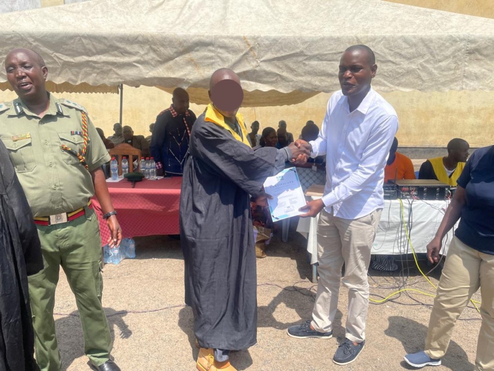 Certificate presentation during programme graduation at a correctional facility.