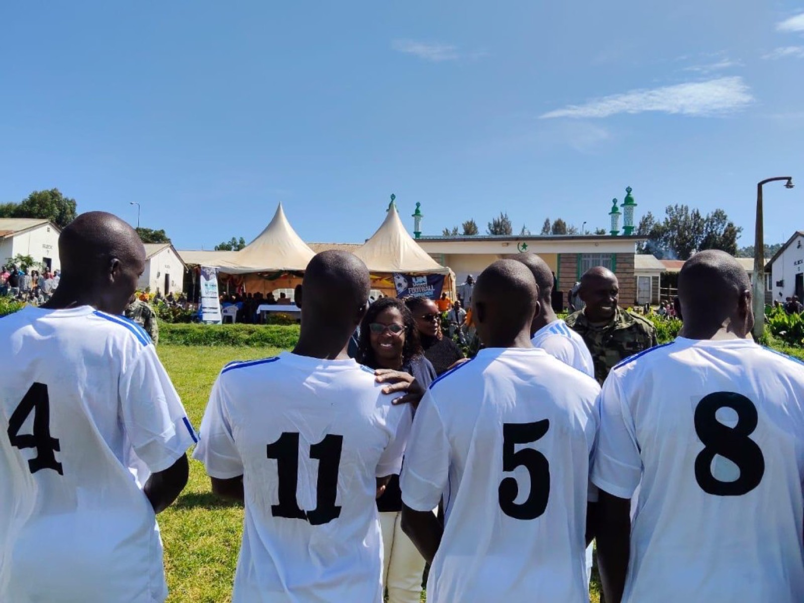UN Football Tournament field scene with participants and banner.