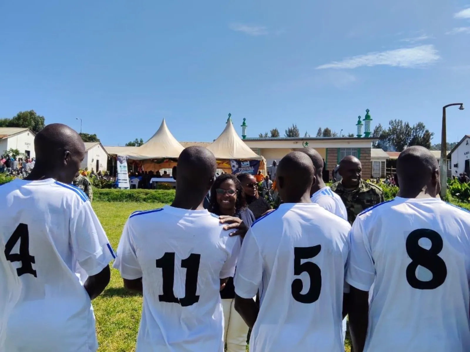 UN Football Tournament field scene with participants and banner.